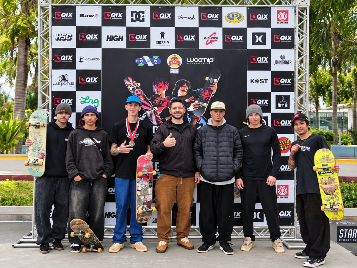 Skatista Eduardo Schommer comemora vitória em competição de skate street no Paraná, com a bandeira de Toledo ao fundo.
