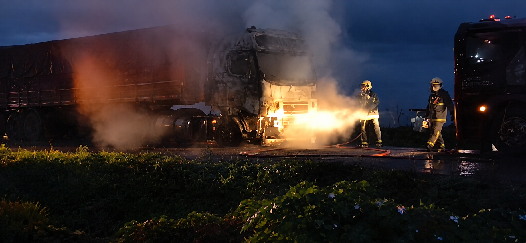 Caminhão com a parte frontal totalmente destruída pelo fogo no acostamento da BR-369