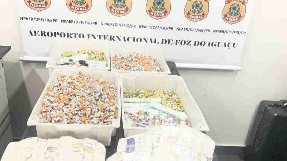 Agentes da Polícia Federal inspecionando bagagens no Aeroporto Internacional de Foz do Iguaçu.
