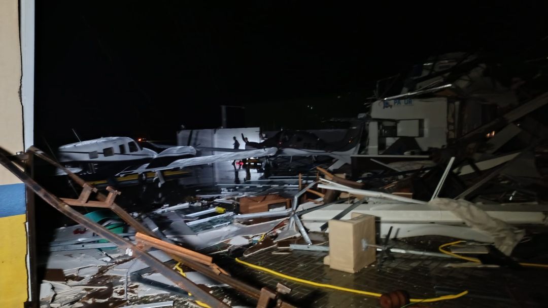 Estruturas metálicas de hangares destruídas e espalhadas pelo chão no Aeroporto Municipal de Toledo após vendaval